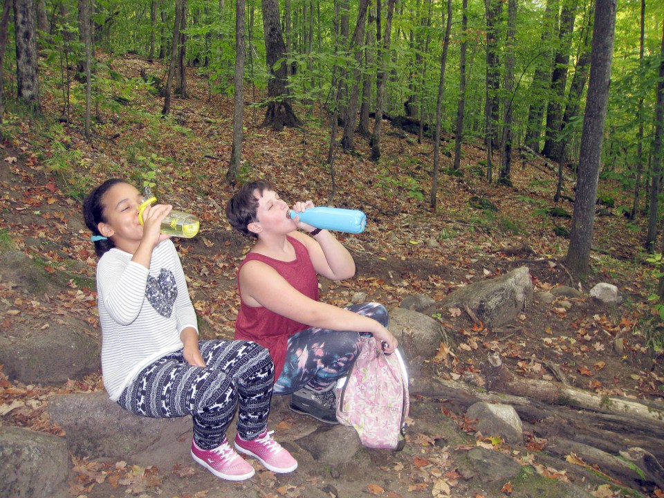 Friends Eniola and Brigid gulp some water halfway up the first climb at Silver Lake Mountain.